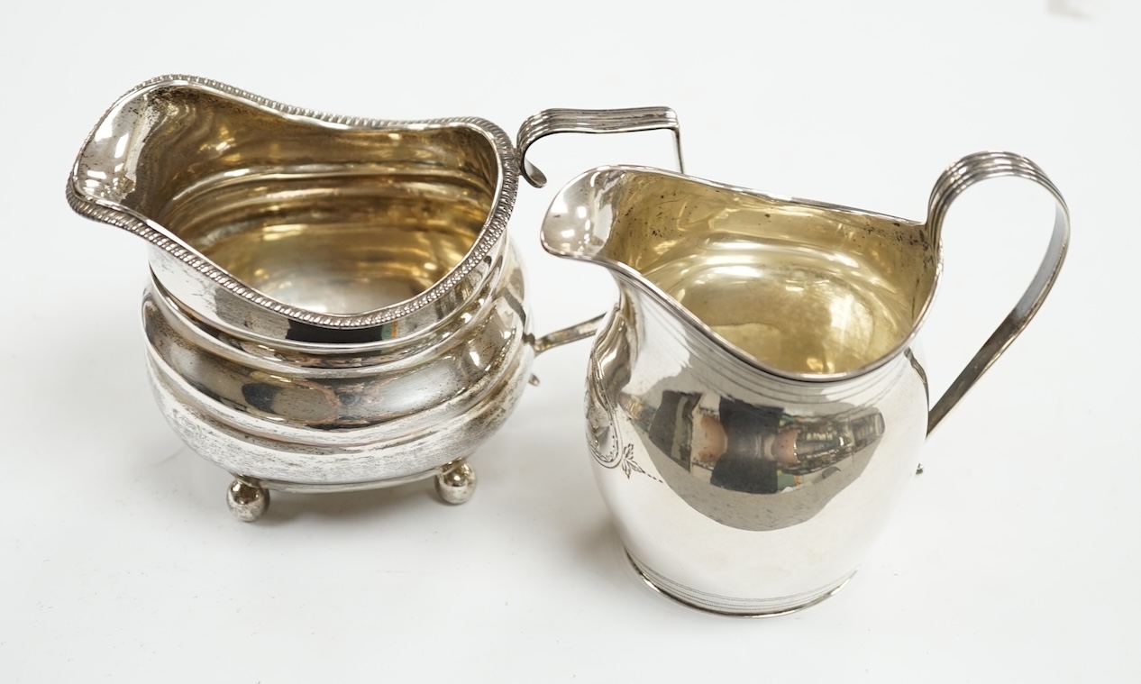 A George III silver helmet shaped cream jug, London, 1806, 10.2cm, together with another George III silver cream jug(repair). Condition - poor to fair